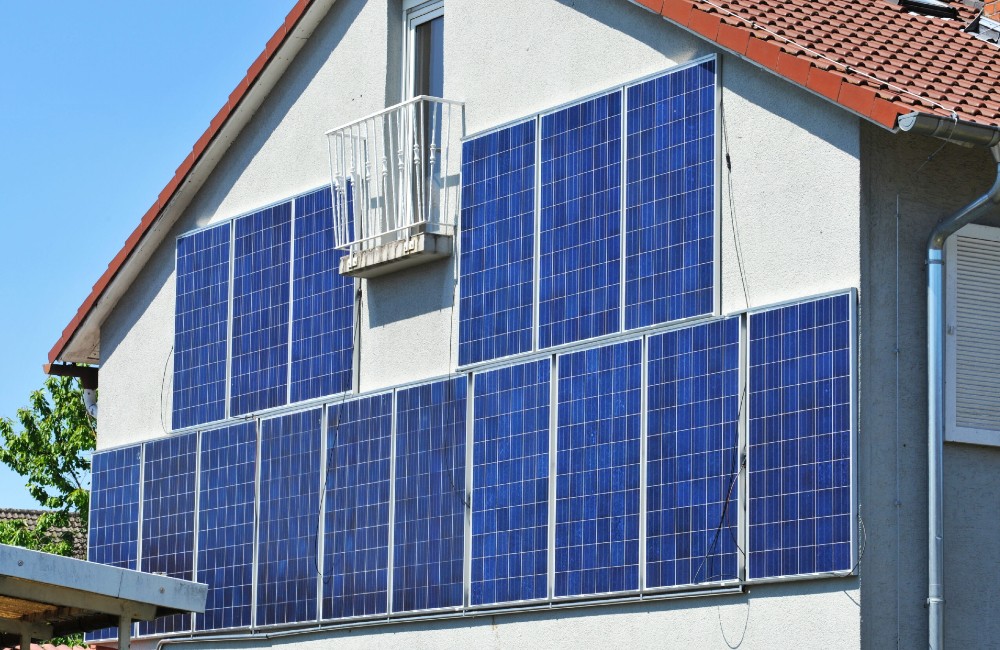Hausfassade mit großflächig montierten Solarmodulen zur Stromerzeugung durch Sonnenenergie.